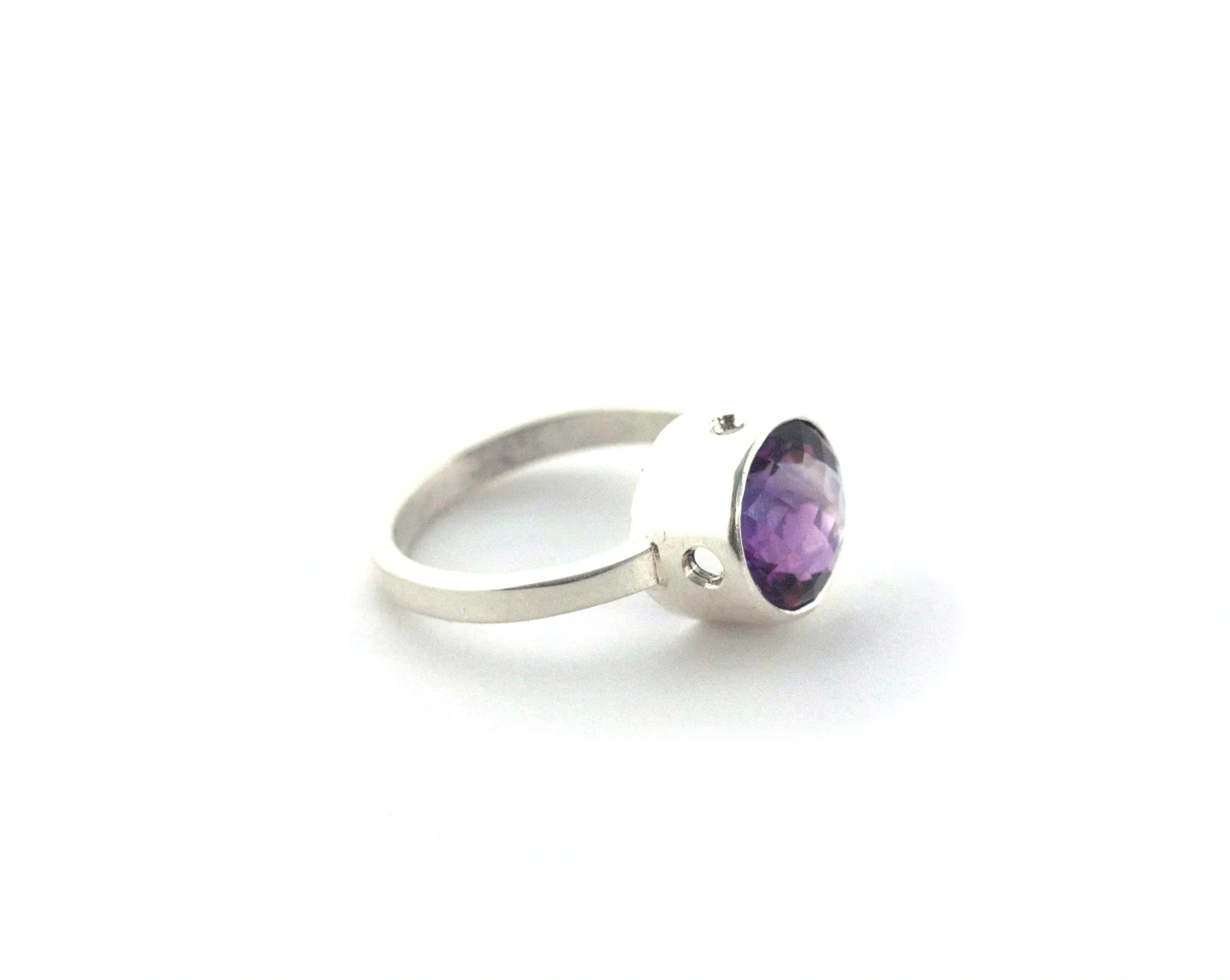 A purple ring is sitting on top of a white surface.