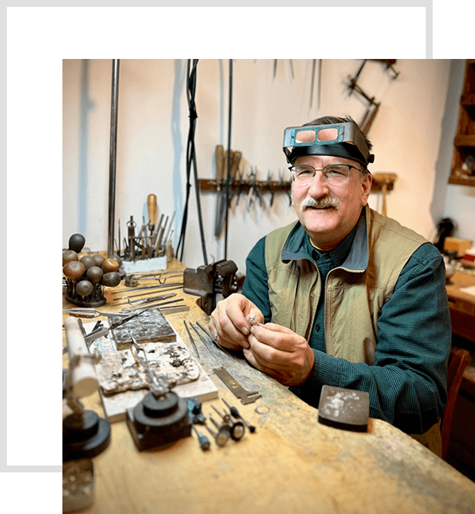 A man sitting at a table with many tools.