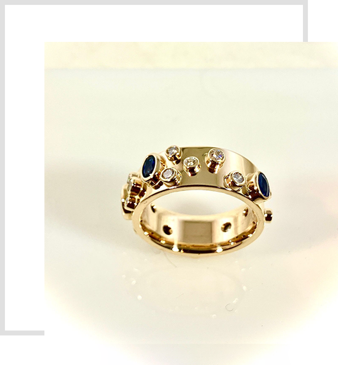 A gold ring with blue stones on top of it.