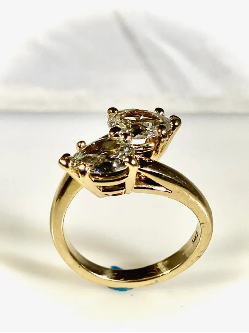 A gold ring with two diamonds on it