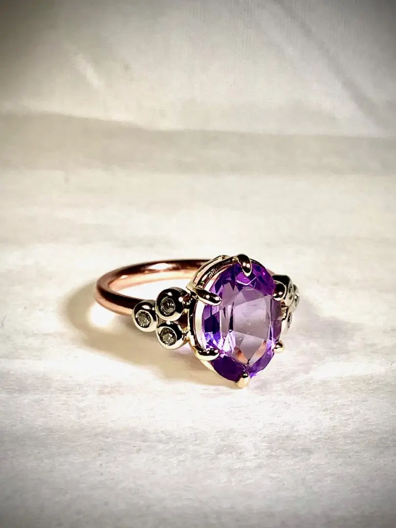 A purple ring sitting on top of a white cloth.