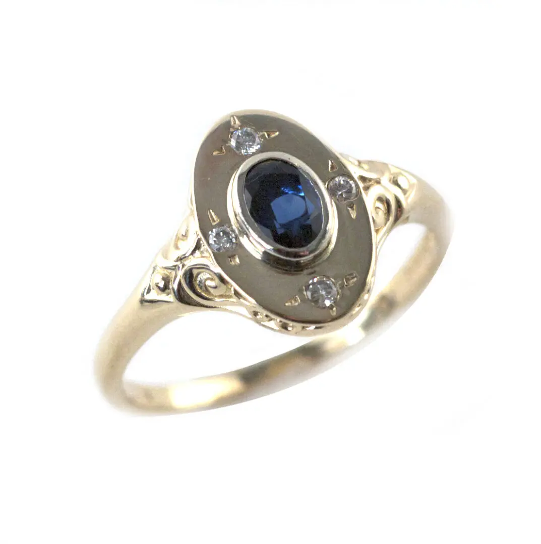 A gold ring with a blue stone on it's side.