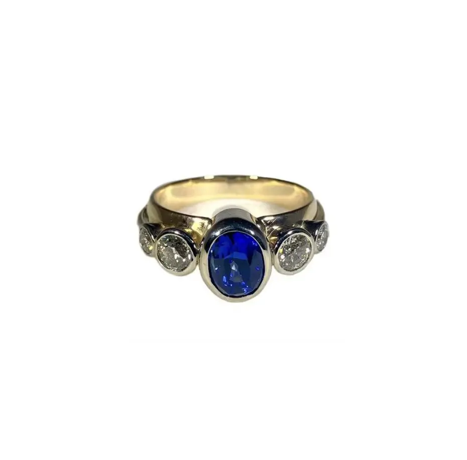 A gold and silver ring with a blue stone.